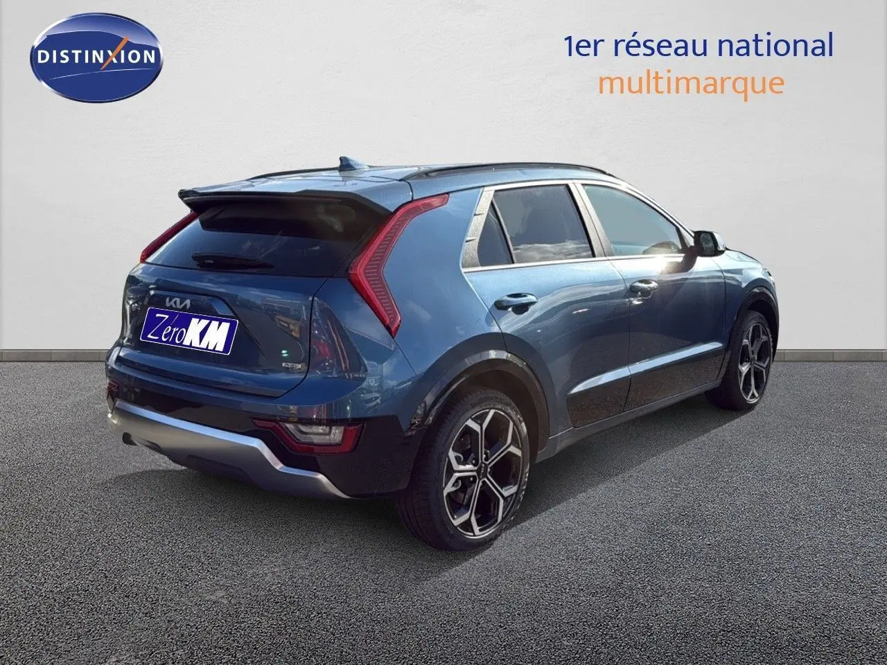 KIA Niro hybride rechargeable bleu minéral métal vu en 3/4 arrière droit, avec feux arrière en forme de boomerang et jantes bi-ton.