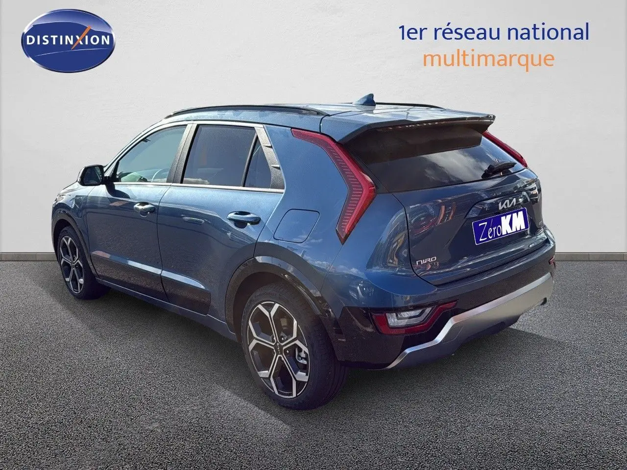 Vue 3/4 arrière droite d'un KIA NIRO bleu minéral métal 2025 avec feux LED et jantes bi-ton distinctives.