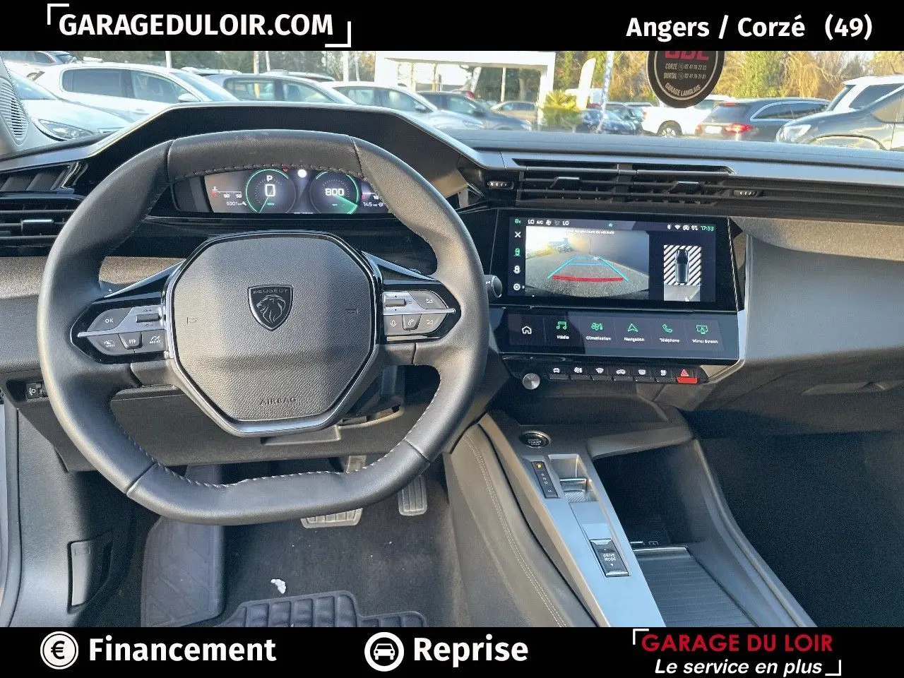 Intérieur Peugeot 308 2024, vue du poste de conduite avec volant compact et écran tactile affichant la caméra de recul.