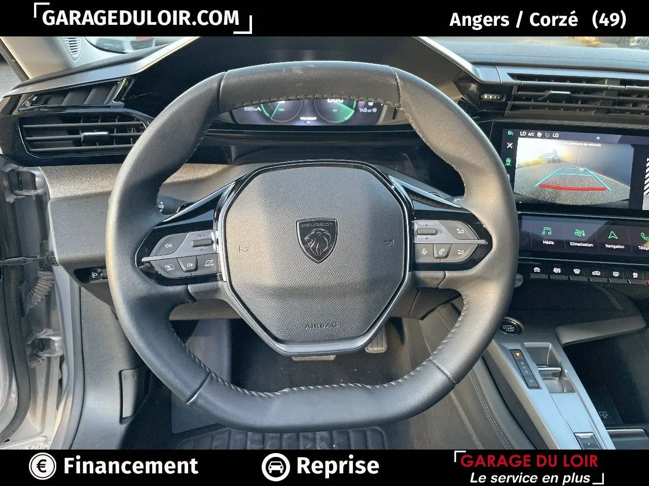 Vue intérieure du volant cuir noir et tableau de bord numérique de la Peugeot 308 Gris Artense 2024 avec écran tactile et caméra de recul.