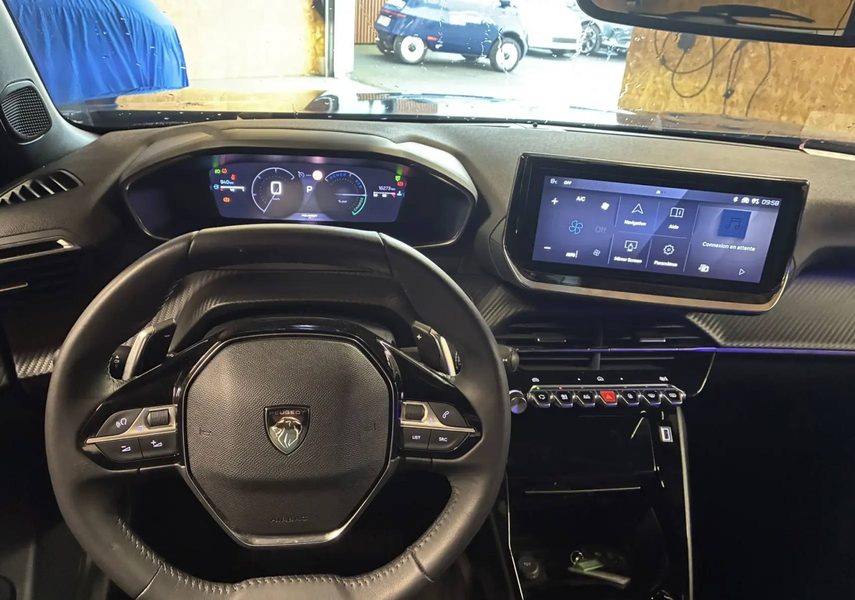 Vue intérieure du tableau de bord et volant noir de la Peugeot 2008 1.2 Hybrid 136 Allure avec écran tactile et affichage numérique.