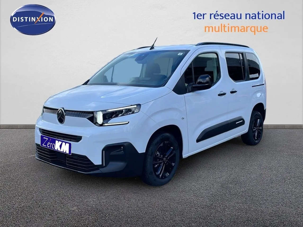 Vue 3/4 avant d’un Citroën Berlingo blanc glacier avec jantes noires et protections latérales noires.