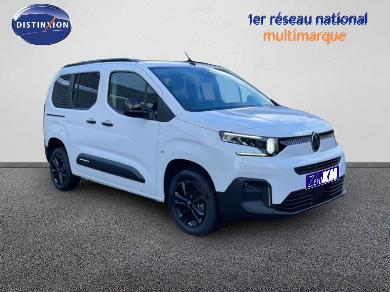 Vue 3/4 avant droite du Citroën Berlingo blanc glacier avec jantes noires et protections latérales noires.