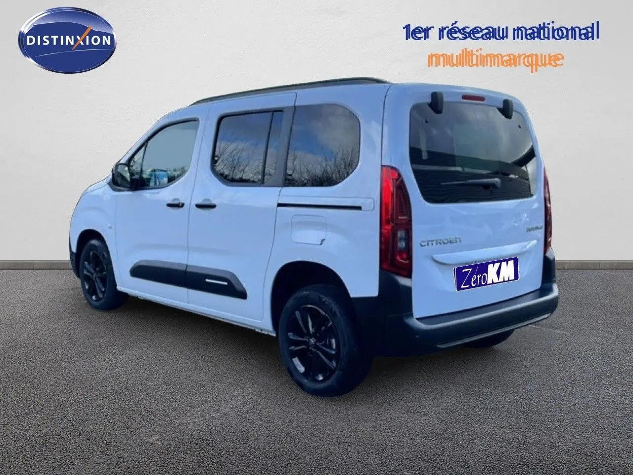 Vue 3/4 arrière droite d'un Citroën Berlingo Multispace blanc glacier avec jantes noires et vitres teintées.