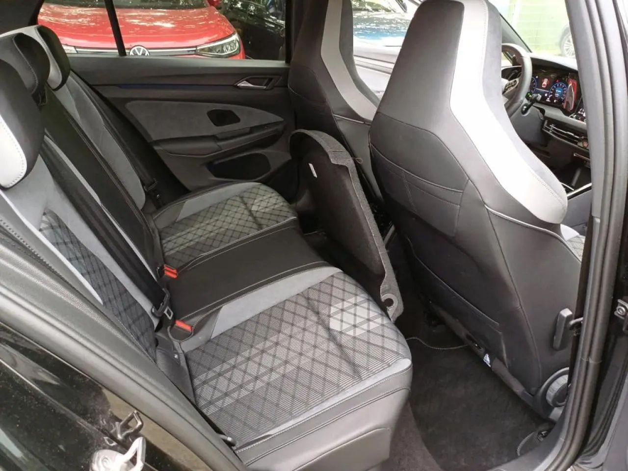 Vue intérieure côté droit de la banquette arrière et des sièges avant en tissu noir et gris de la Volkswagen Golf VIII R-Line Black.