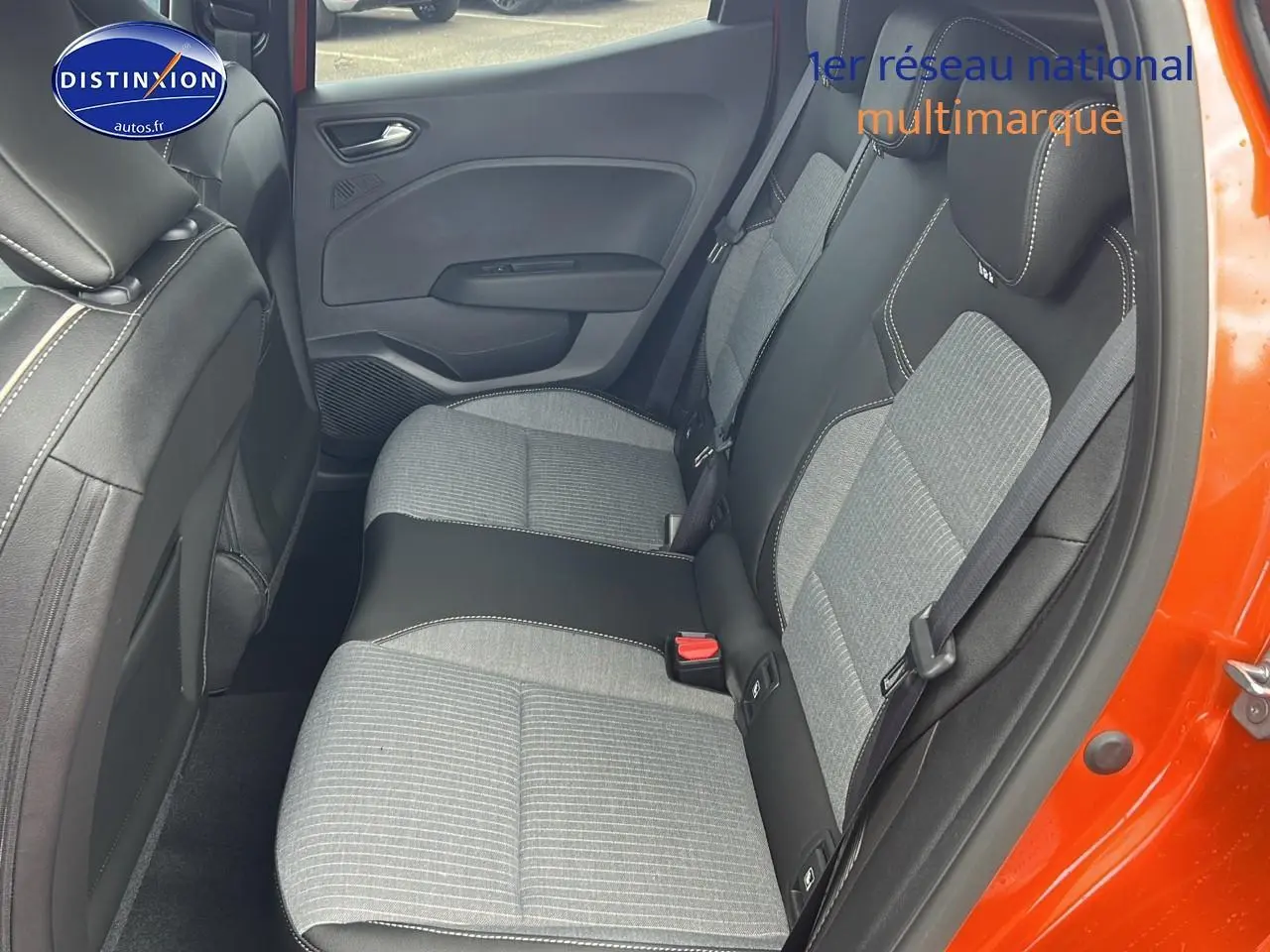 Vue intérieure du côté droit sur la banquette arrière grise et noire d'une Renault Clio V orange Valencia avec porte ouverte.