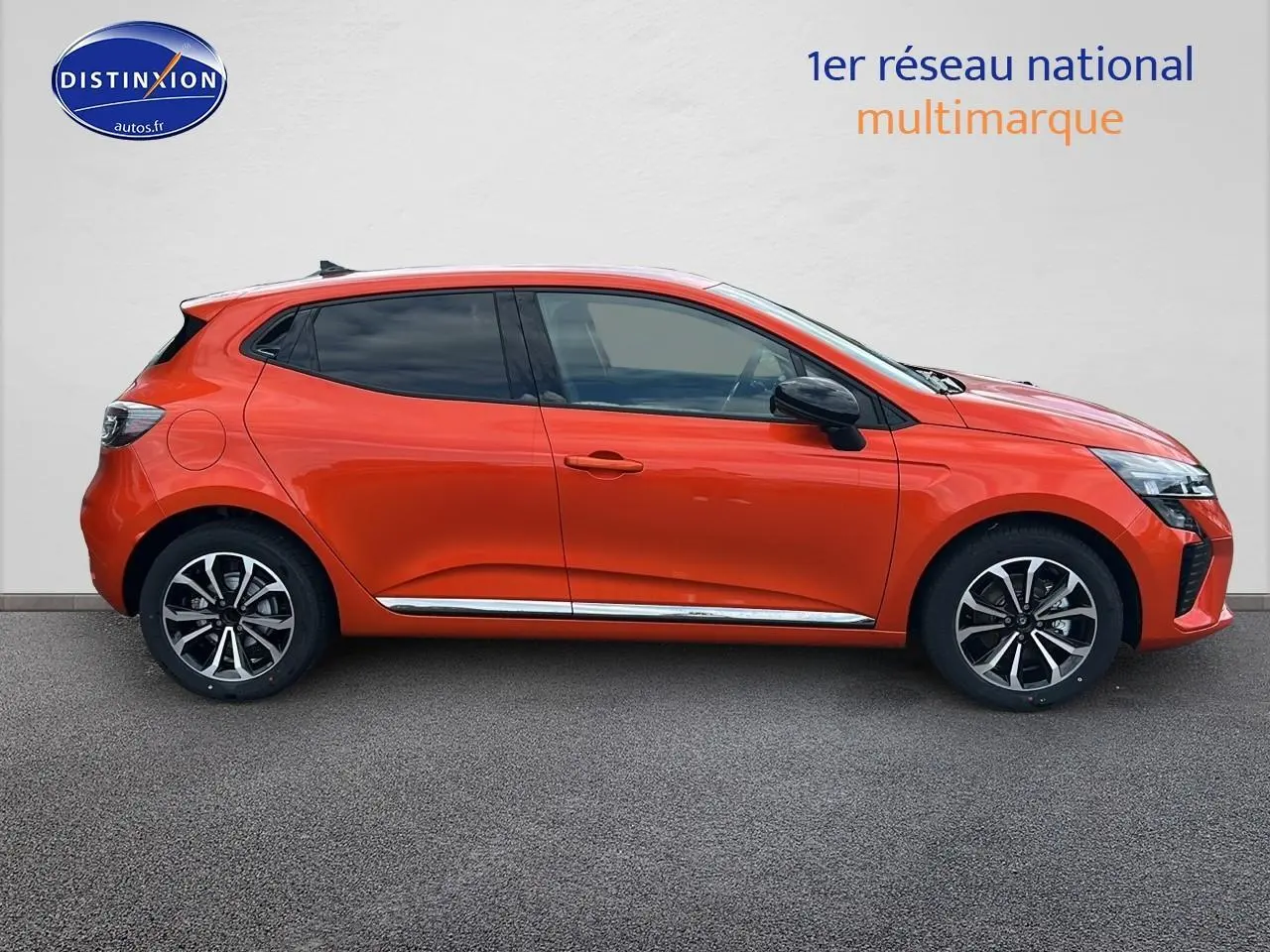 Profil droit d'une Renault Clio V orange Valencia 2025 avec jantes alliage et vitres arrière surteintées.