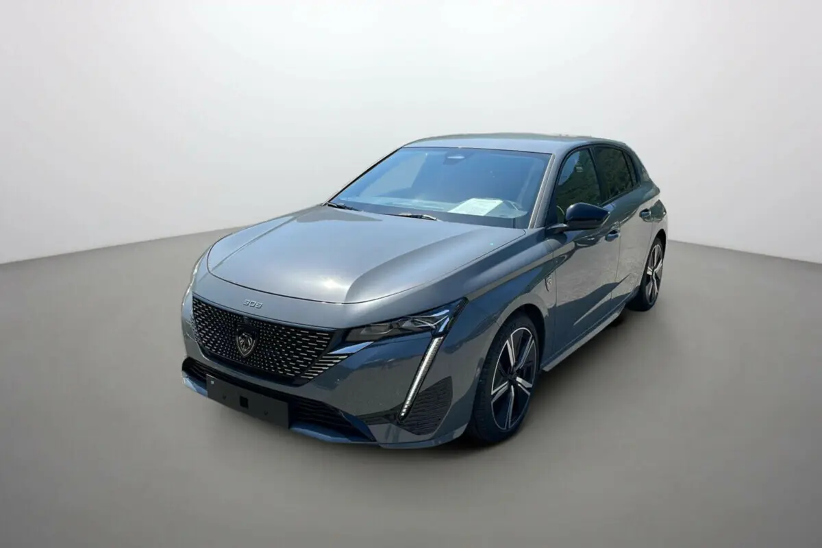 Peugeot 308 2025 gris selenium vue 3/4 avant droit avec calandre noire et phares LED distinctifs.