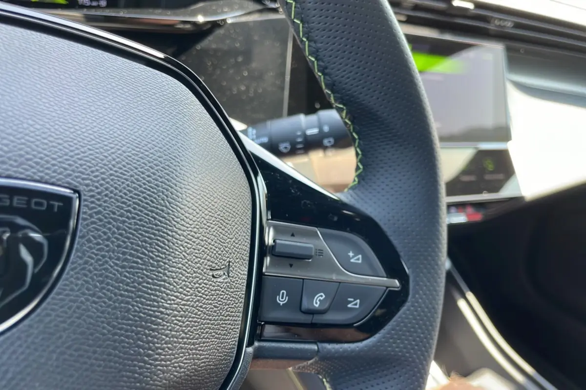 Gros plan sur le volant cuir perforé avec surpiqûres vertes de la Peugeot 308 1.5 HDI 130 EAT8 GT 2025.
