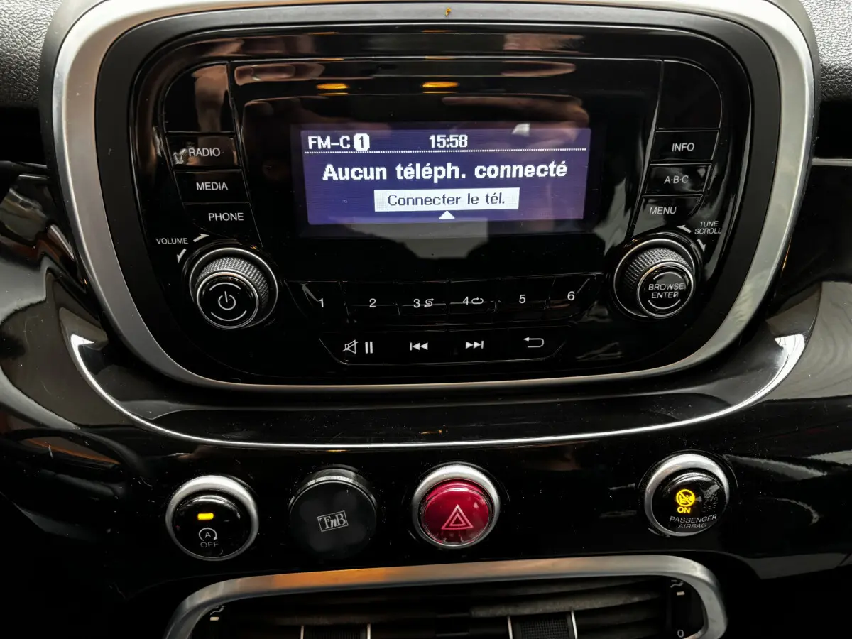 Gros plan sur la console centrale noire du Fiat 500X 2018, affichant l’écran radio et les commandes de climatisation.