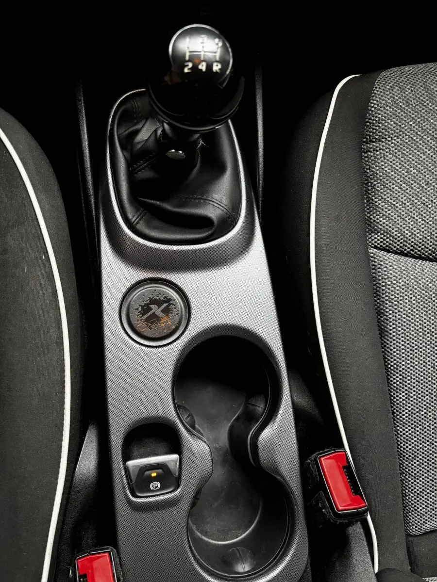 Vue plongeante sur la console centrale noire de la Fiat 500X 2018, avec levier de vitesse manuel et porte-gobelets.