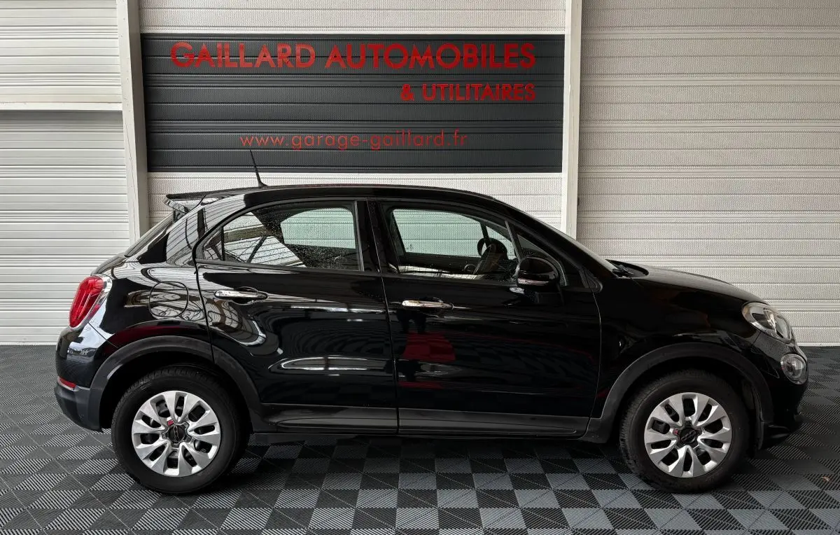 Profil droit de la Fiat 500X noire 2018, compacte avec jantes argentées et poignées de porte chromées.