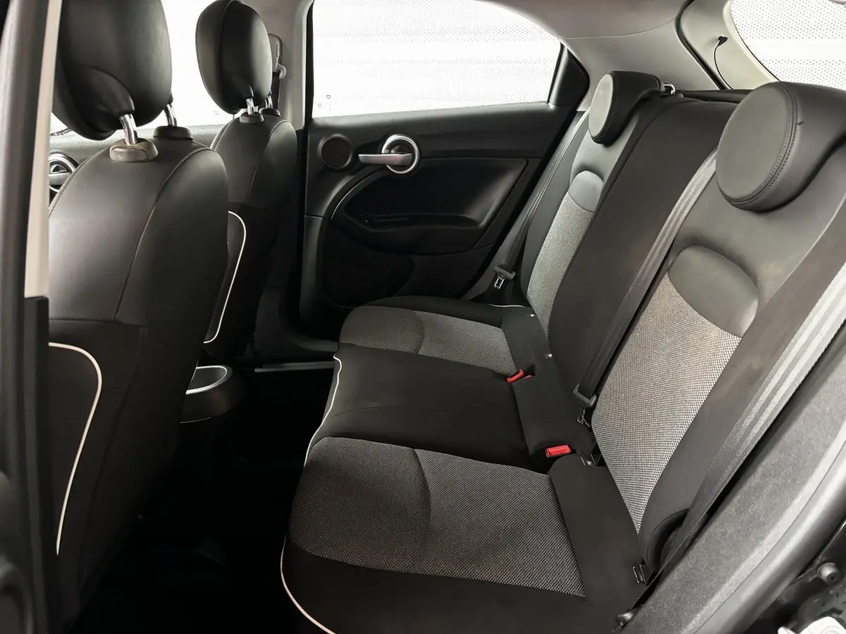 Vue intérieure arrière droite des sièges tissu noir et gris de la Fiat 500X 2018, avec appuie-têtes ronds.