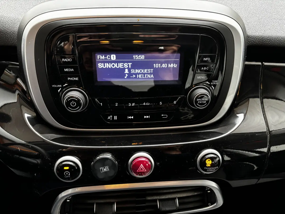 Vue rapprochée du tableau de bord noir brillant de la Fiat 500X 2018, avec écran radio et commandes centrales.