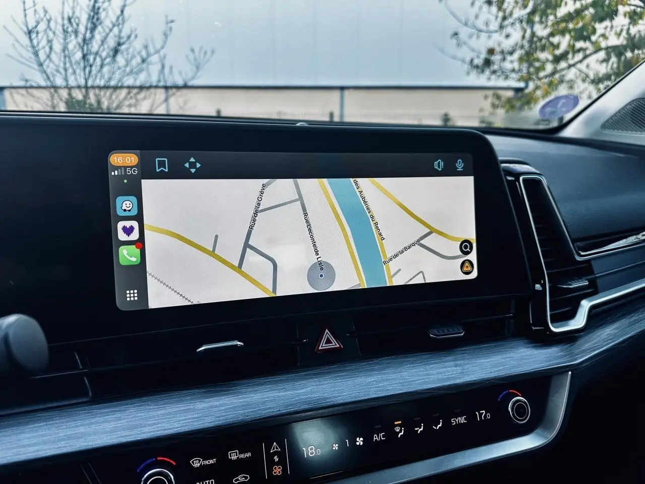 Vue rapprochée de l'écran tactile 12,3 pouces du tableau de bord du Kia Sportage noir 2023 affichant la navigation.