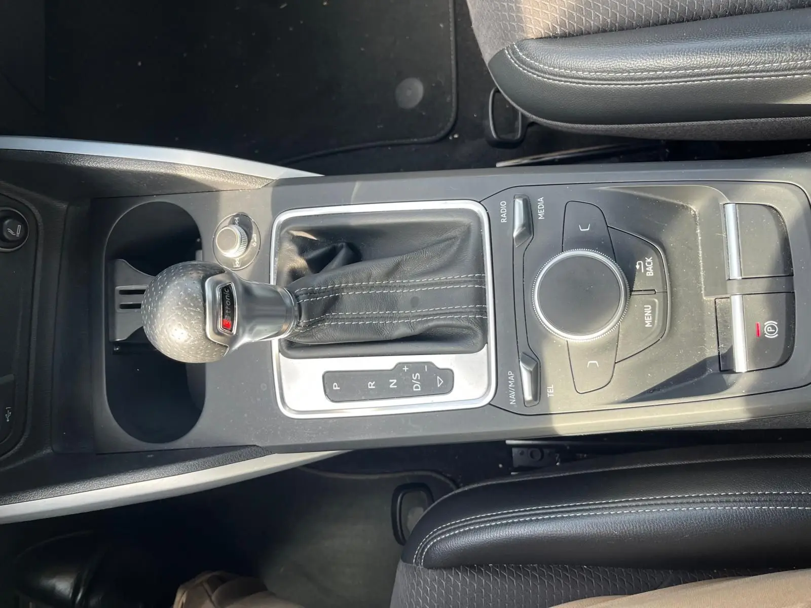 Vue rapprochée de la console centrale noire de l'Audi Q2 2018 avec levier de vitesse S-Tronic et commandes multimédia.