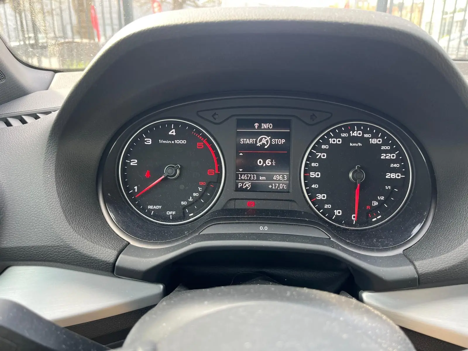 Vue rapprochée du tableau de bord noir de l'Audi Q2 blanc, avec compte-tours, compteur de vitesse et écran central digital.