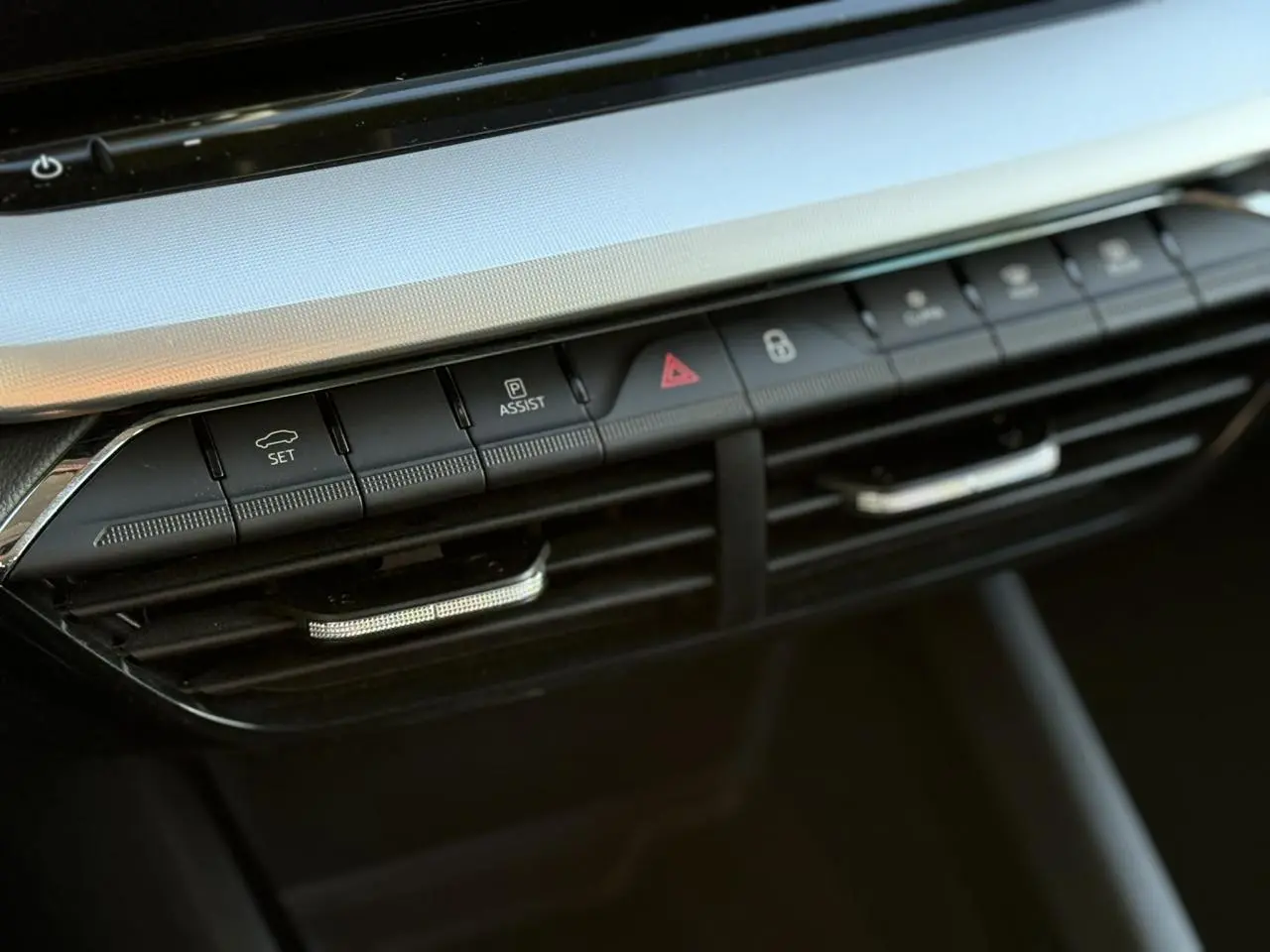 Gros plan sur la console centrale noire de la Skoda Octavia Combi 2022, mettant en valeur les boutons de commande et les aérateurs.