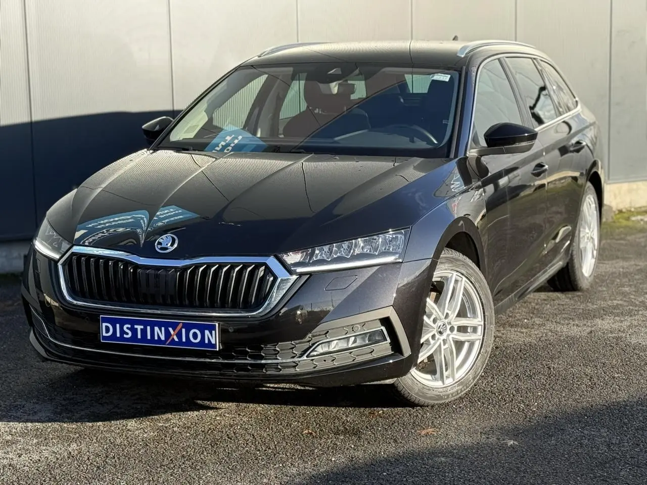 Vue 3/4 avant droite d'une Skoda Octavia Combi noire avec calandre chromée et jantes alliage 17 pouces.