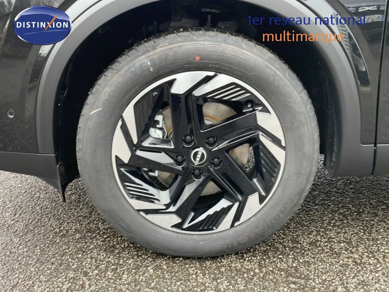 Gros plan sur la roue avant droite du Nissan Qashqai noir perle métal avec jante alliage au design moderne.