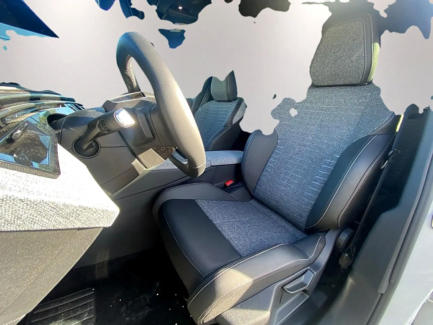 Vue intérieure côté conducteur du Peugeot 5008 Hybrid 145 allure e-dcs6 2025 avec sièges tissu et cuir gris.