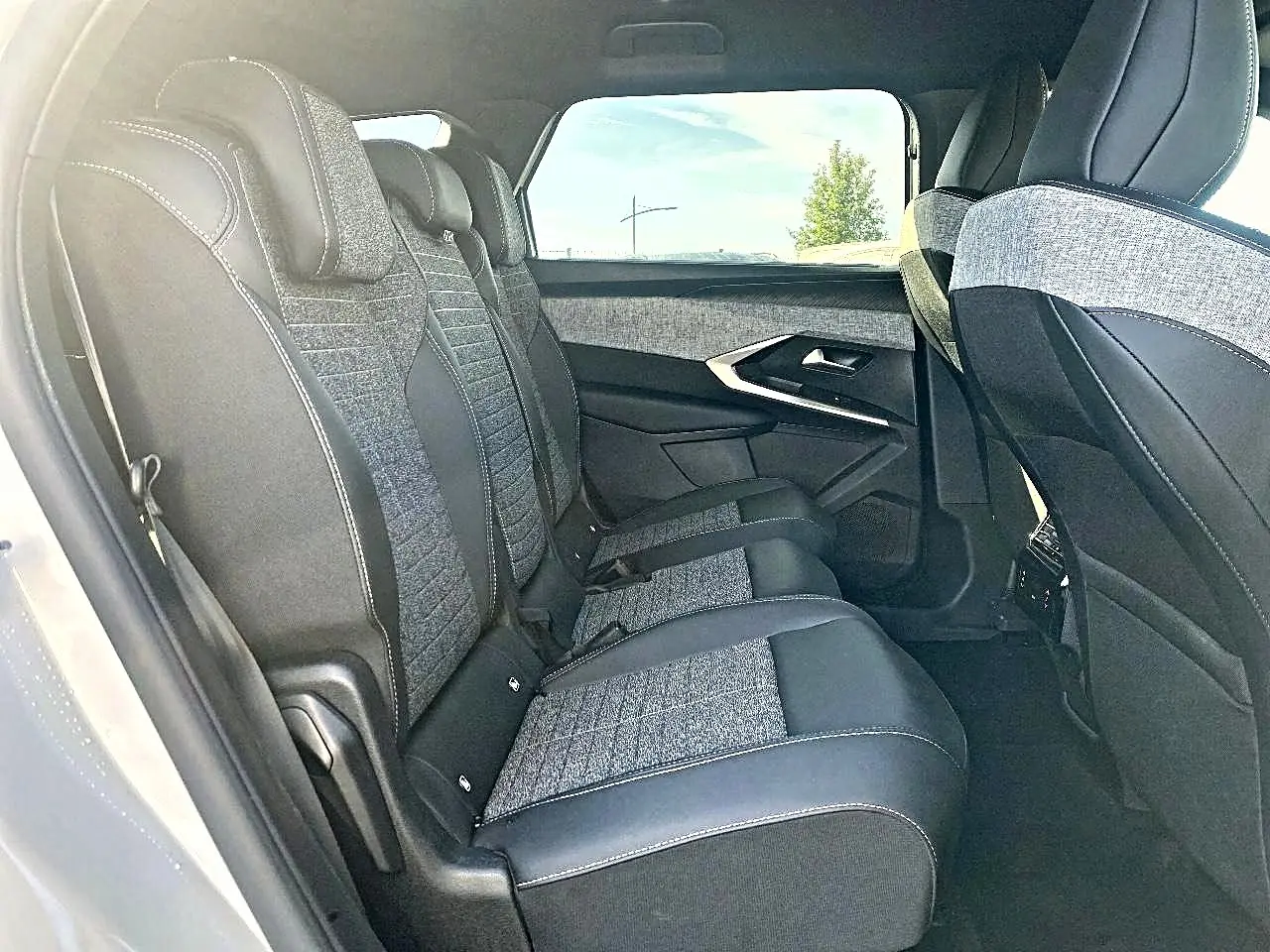 Vue intérieure côté gauche des sièges arrière en tissu gris et cuir noir du Peugeot 5008 Hybrid 145 allure e-dcs6 2025.