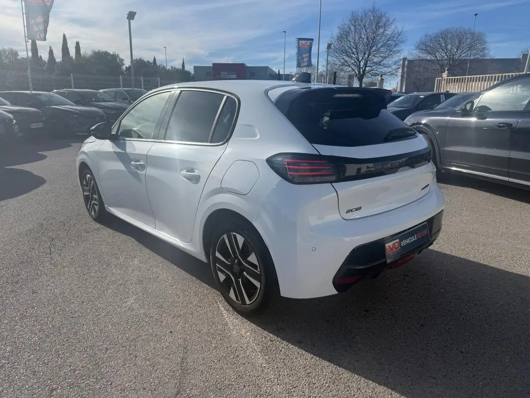 Peugeot 208 Hybrid blanc vue 3/4 arrière droit, avec feux arrière noirs et jantes alliage distinctives.