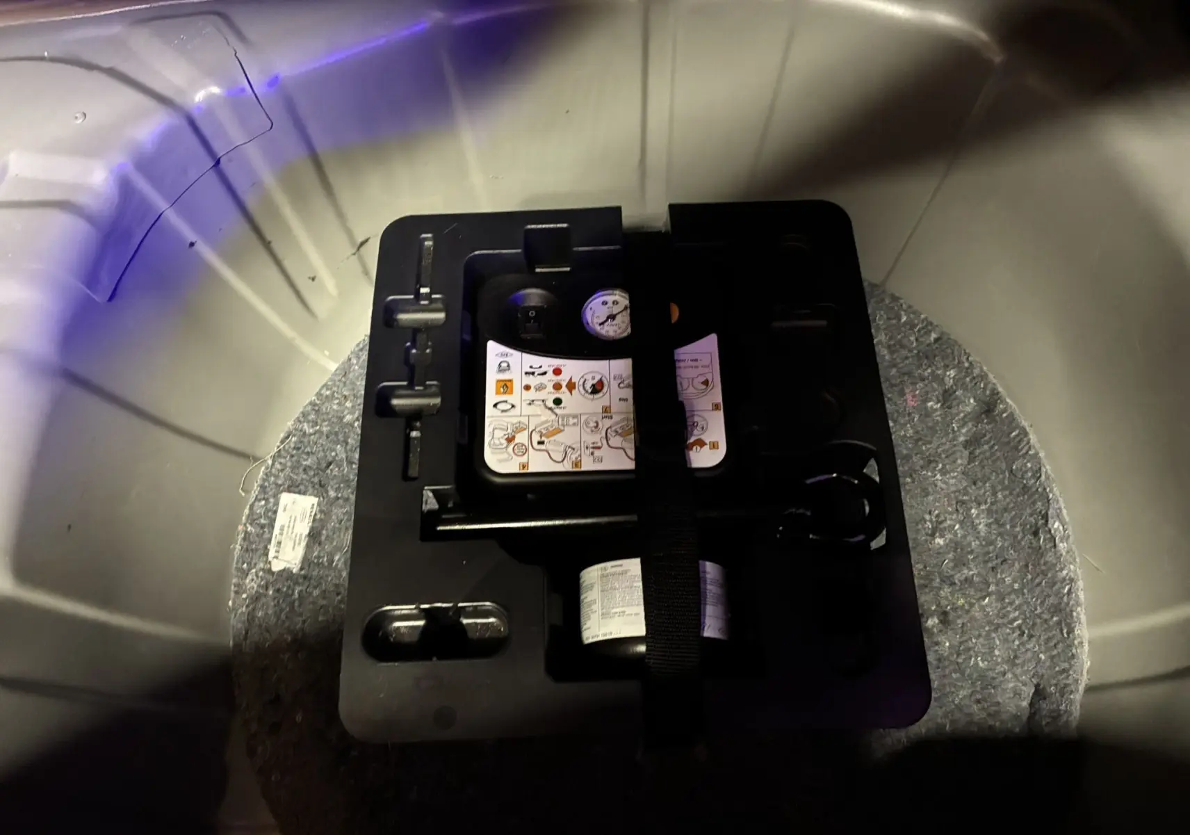 Gros plan sur le kit de réparation de pneu dans le coffre d’un Renault Captur gris, version essence 2021.