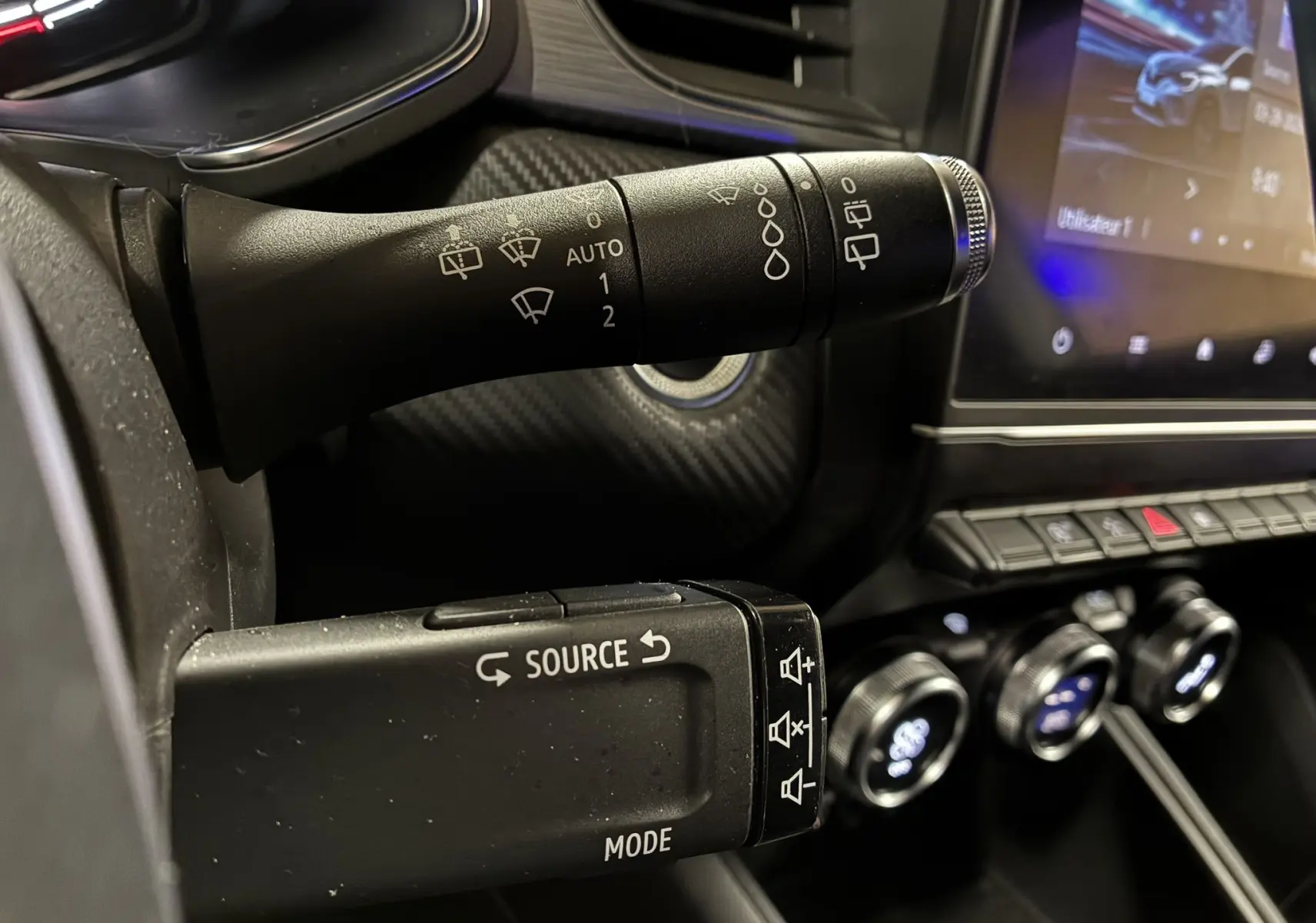 Gros plan sur les commandes au volant du Renault Captur gris 1.3 TCE 140 EDC RS Line, avec tableau de bord et écran tactile visibles.