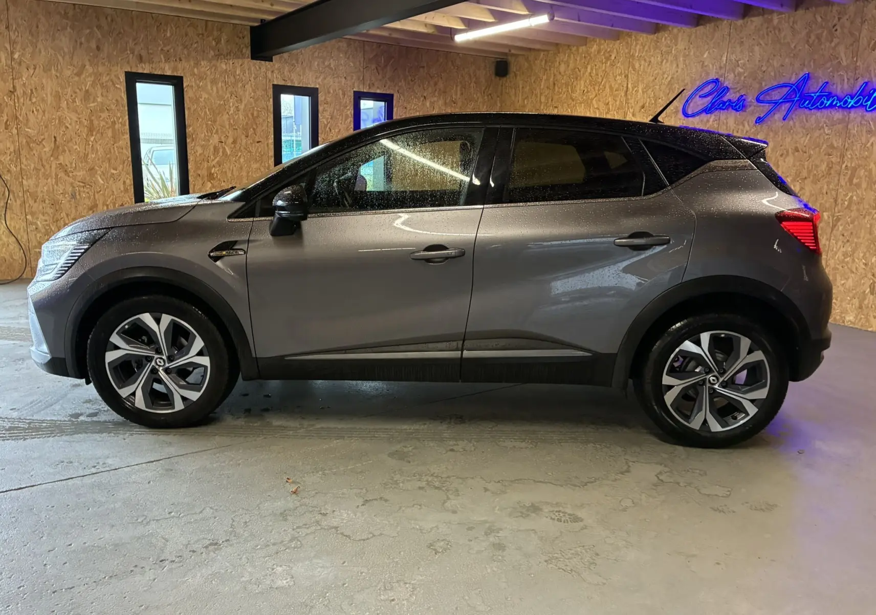 Vue de profil côté gauche d'un Renault Captur gris 1.3 TCE 140 EDC RS Line avec jantes alliage et toit noir.