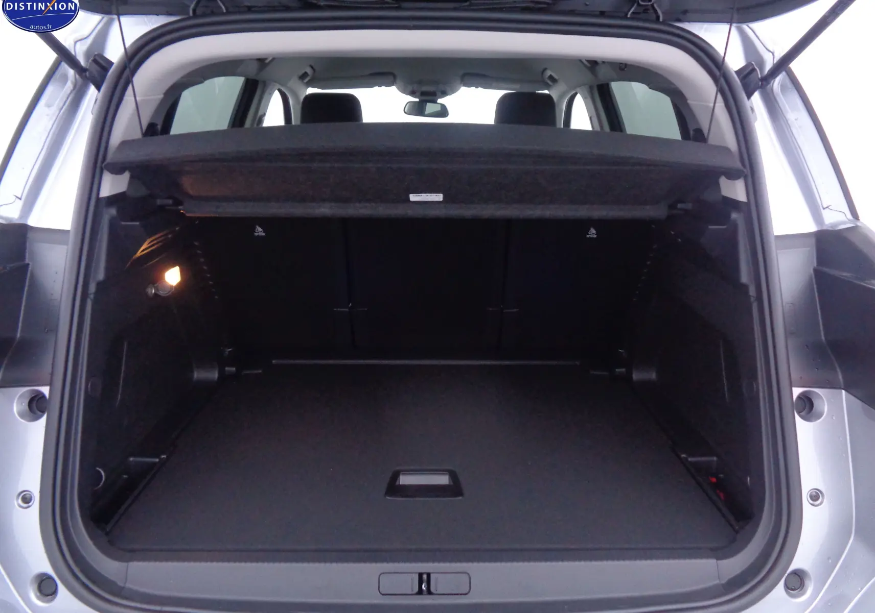 Coffre ouvert vu de l'arrière d'un Citroën C5 Aircross gris Artense, montrant un espace de chargement spacieux et propre.