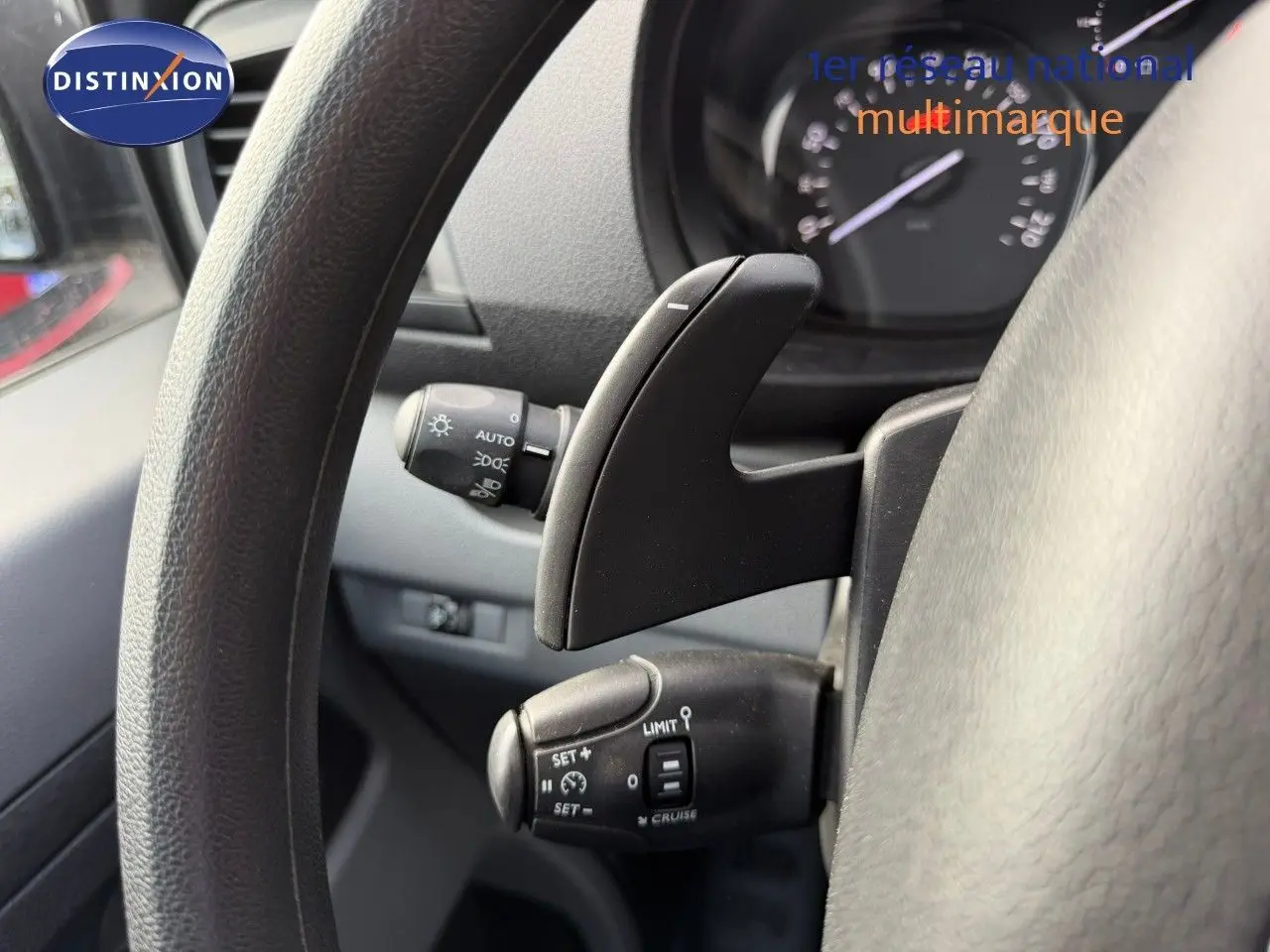 Gros plan sur les commandes au volant du fourgon Opel Vivaro gris, montrant le régulateur de vitesse et palettes de boîte automatique.