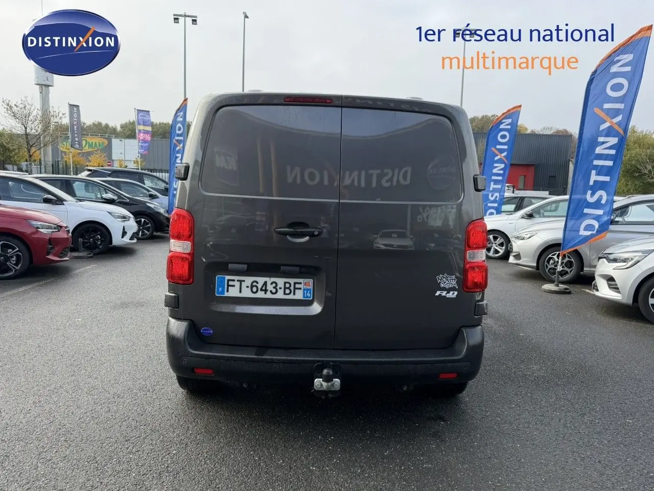 Vue arrière d'un Opel Vivaro Fourgon gris foncé avec attelage et plaque "OCCASION" visible sur un fond neutre.