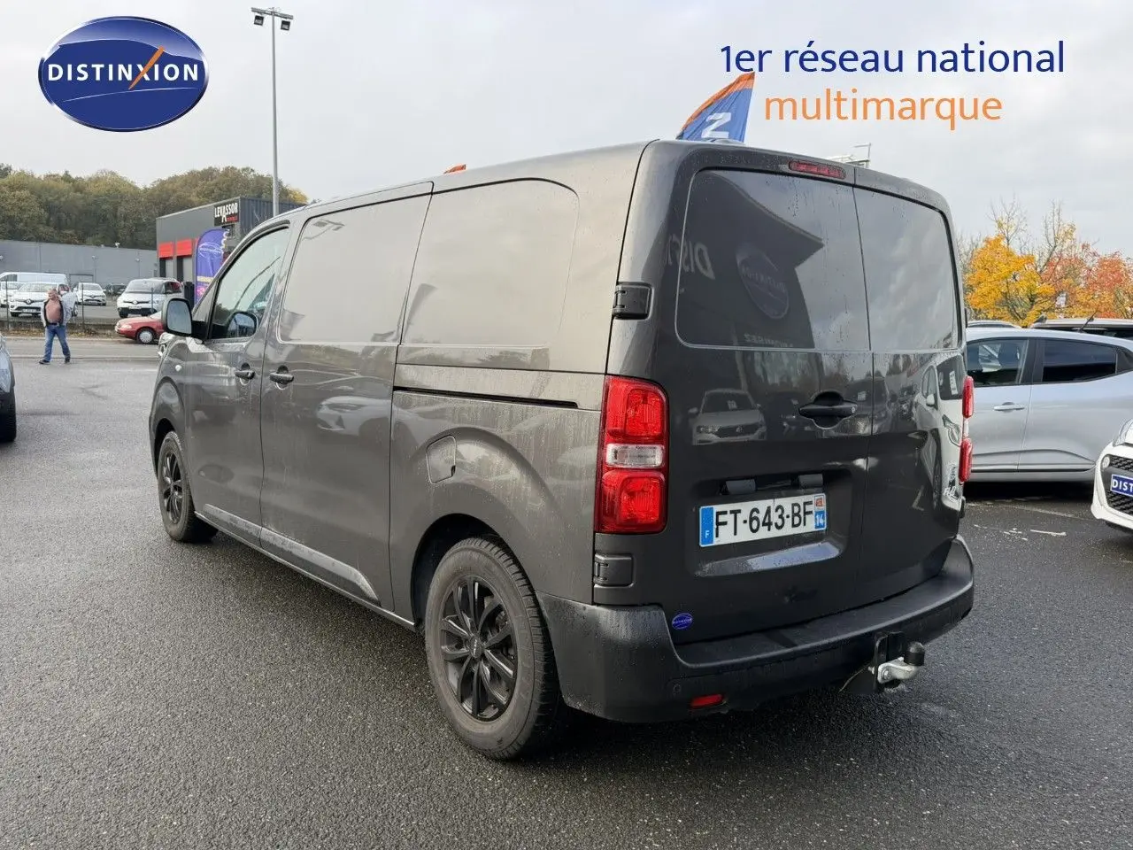 Opel Vivaro Fourgon gris Pierre de Lune métallisé vu en 3/4 arrière droit avec attelage et jantes noires.