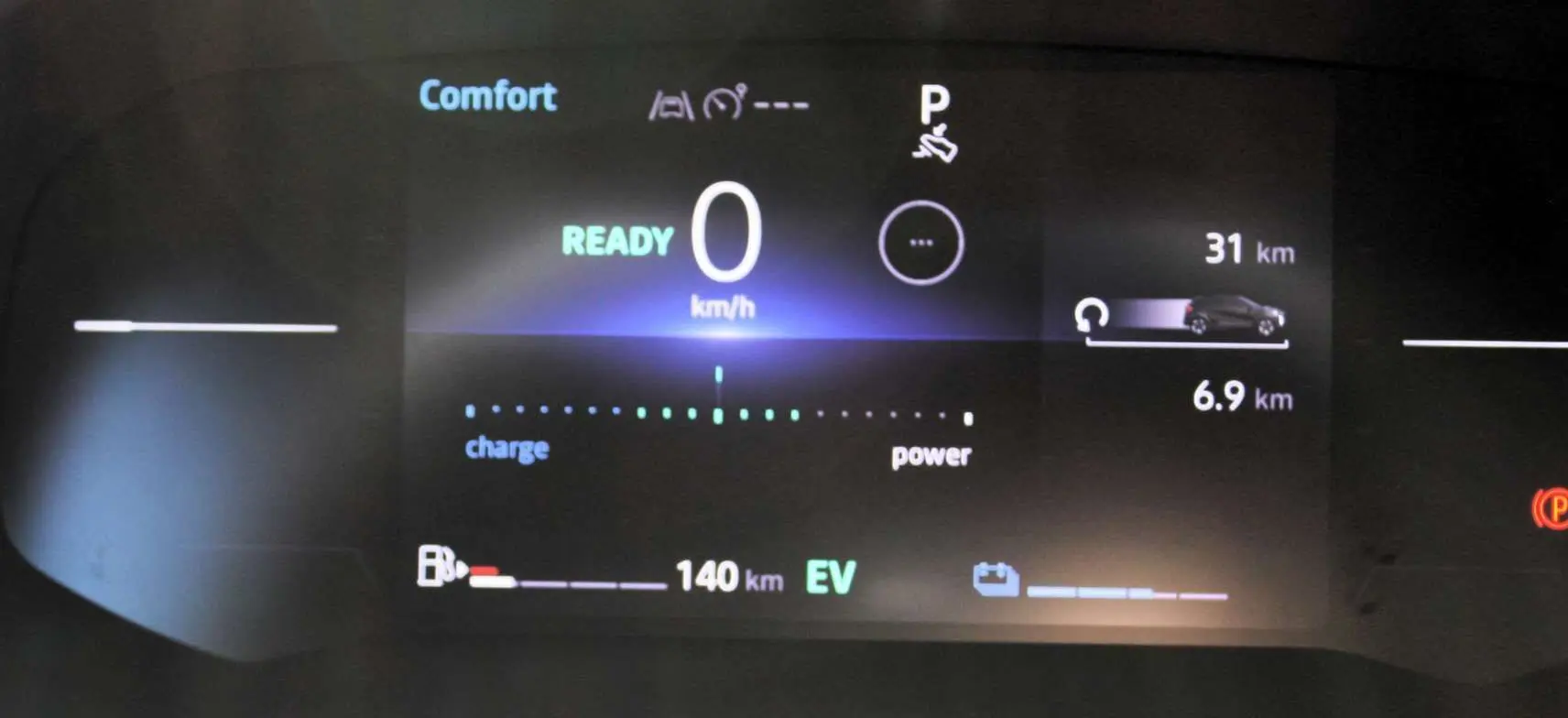 Tableau de bord numérique du Renault Captur 2025 affichant la vitesse à zéro et l'autonomie hybride en mode confort.