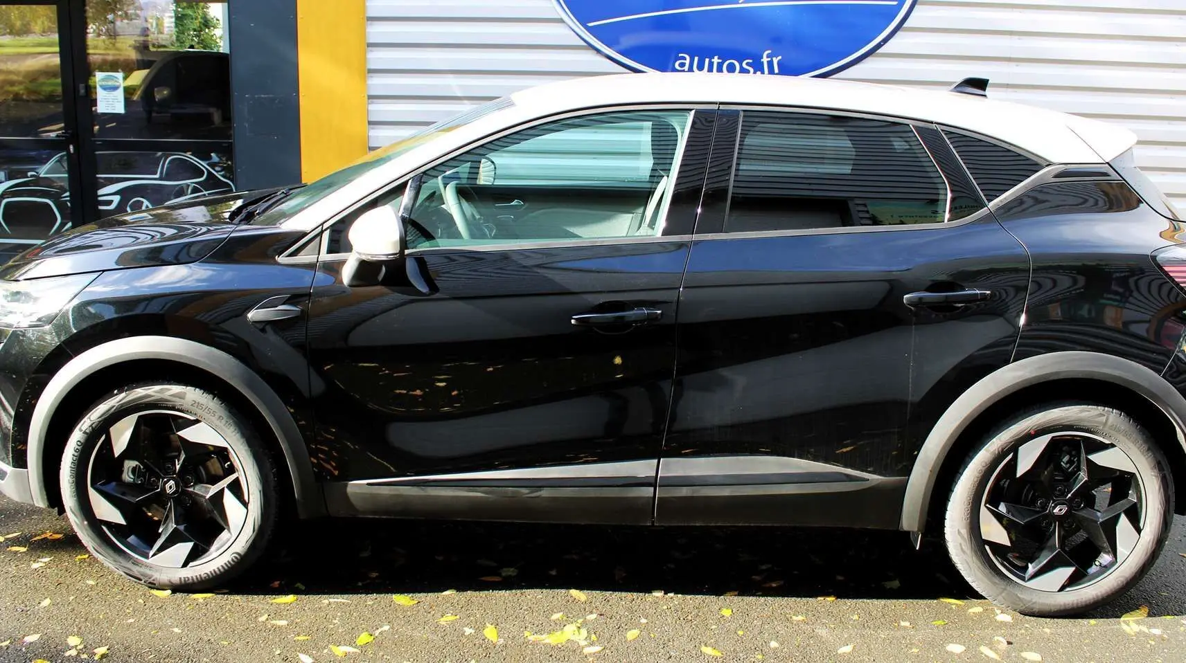 Profil côté gauche du Renault Captur 2025 noir métal avec toit gris, jantes noires au design géométrique.