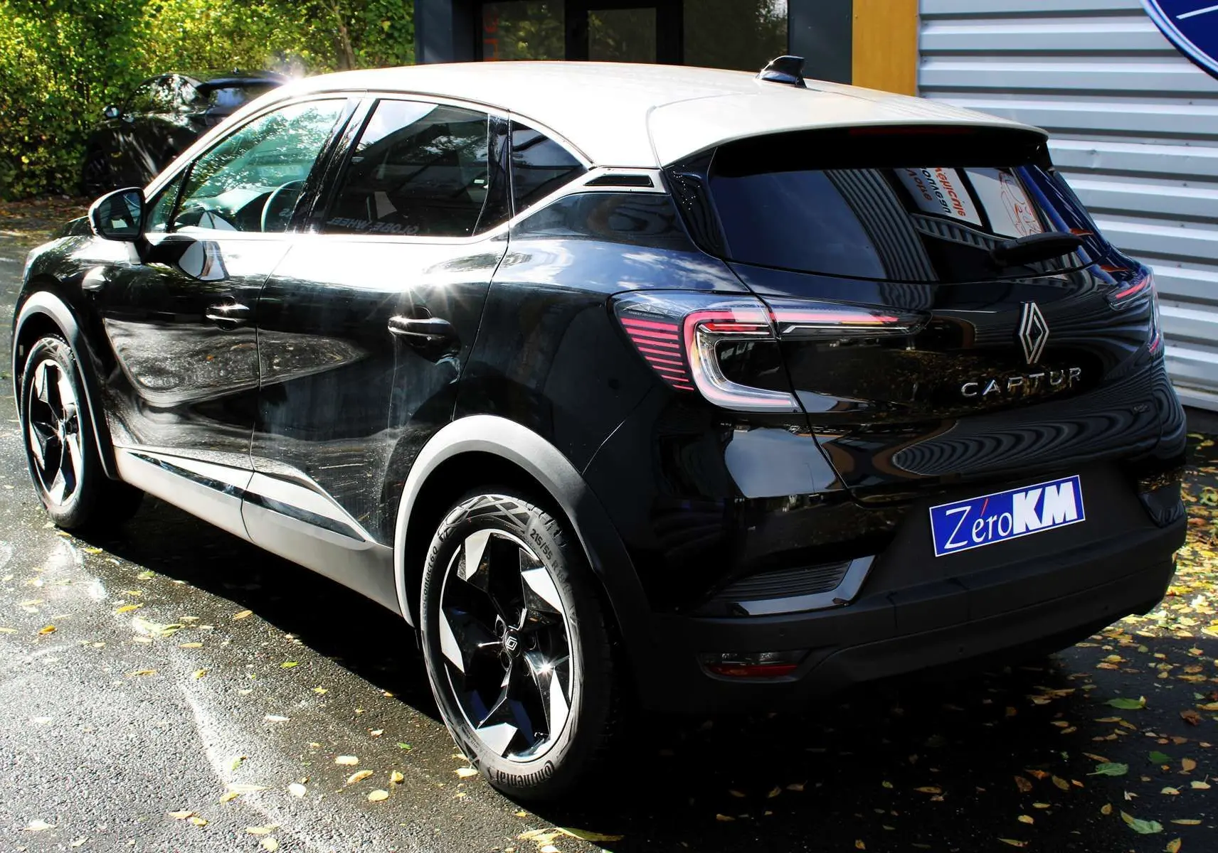 Vue 3/4 arrière droite du Renault Captur 2025 noir métal avec toit gris et jantes biton distinctives.