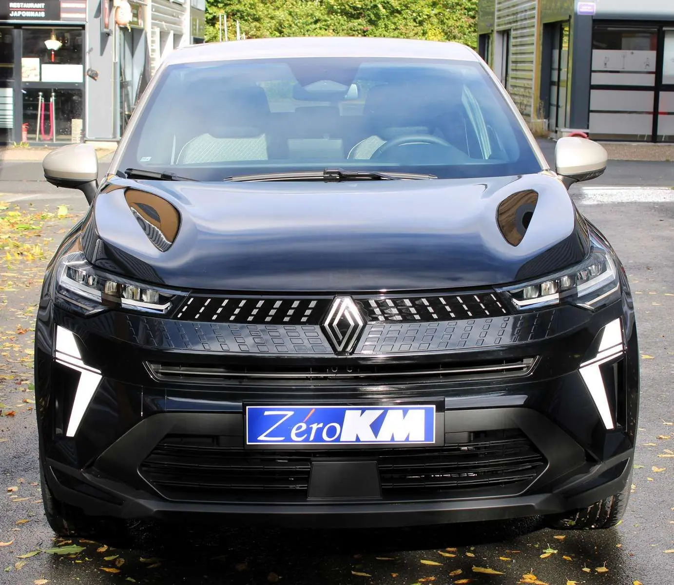 Vue frontale d'un Renault Captur 2025 noir métal avec toit gris, éclairage LED distinctif et plaque Zéro KM.