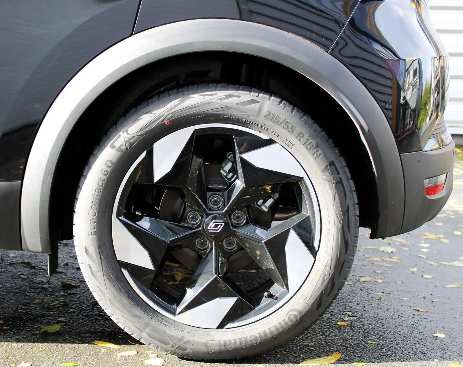 Gros plan sur la roue arrière droite du Renault Captur noir métal avec jante biton noire et argentée design étoile.