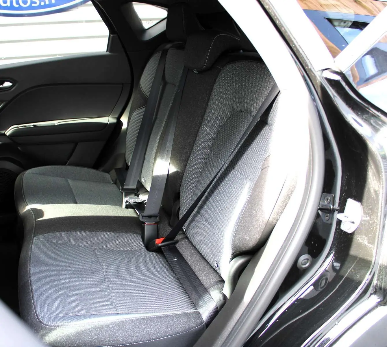 Vue intérieure côté droit des sièges arrière gris du Renault Captur 2025 noir métal avec ceinture de sécurité.