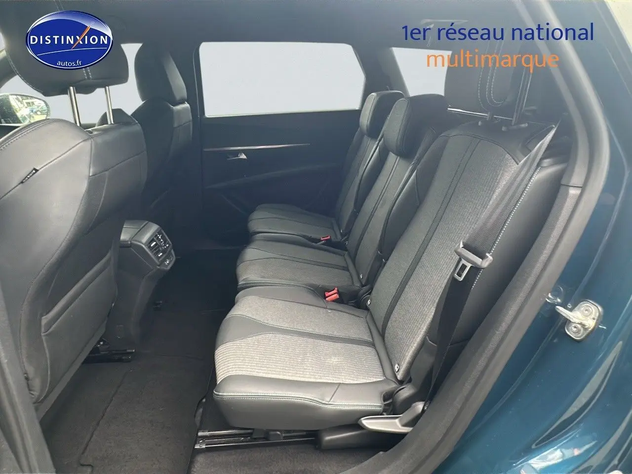 Vue latérale droite sur l'intérieur arrière bleu du Peugeot 5008 2024 avec sièges en tissu et cuir noir.