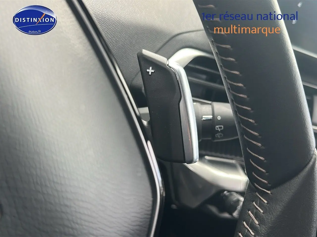 Gros plan sur la palette de changement de vitesse à droite du volant cuir noir du Peugeot 5008 bleu 2024.