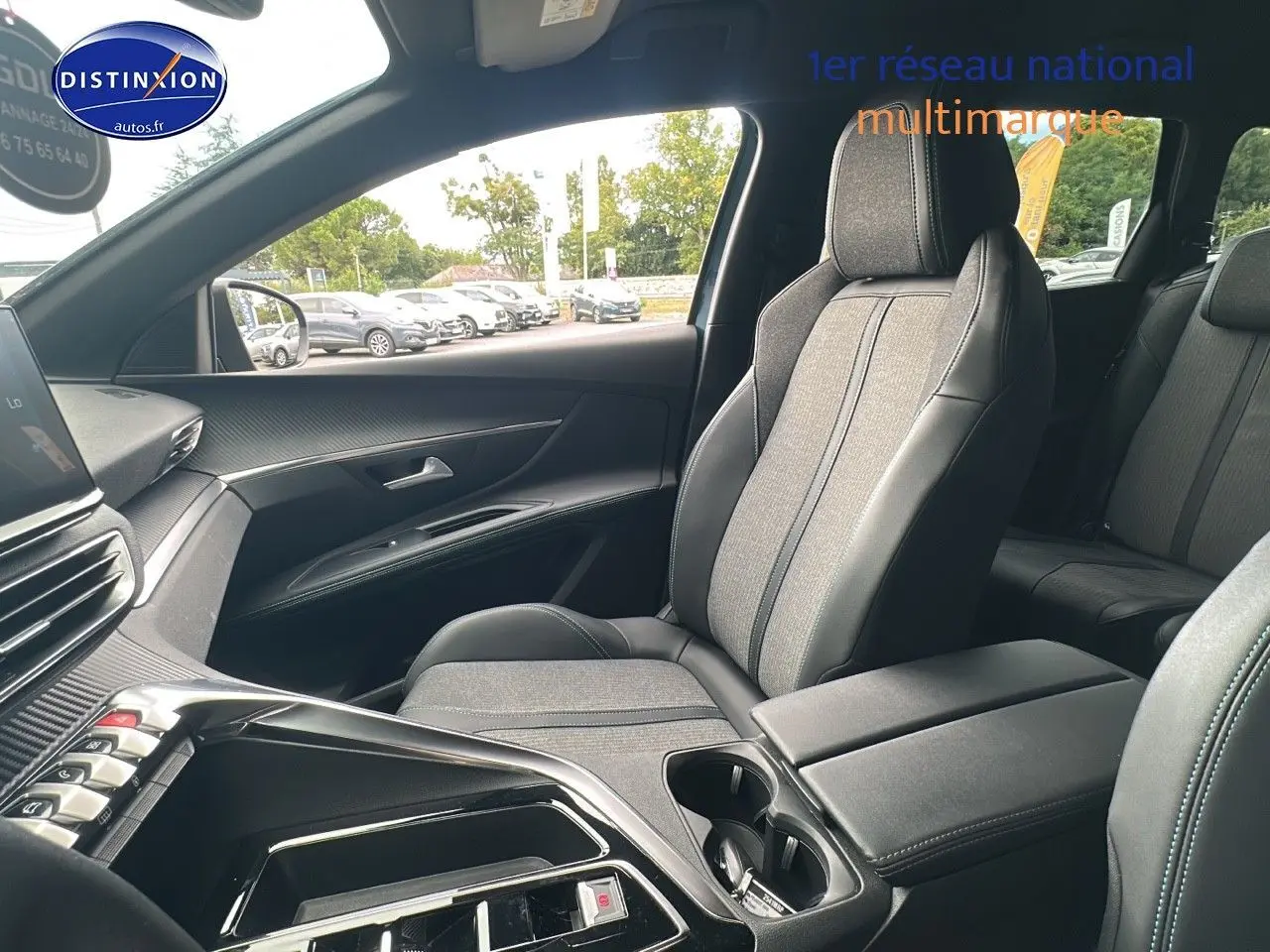 Intérieur du PEUGEOT 5008 2024 côté passager, sièges TEP gris et console centrale avec rangements et porte-gobelets.