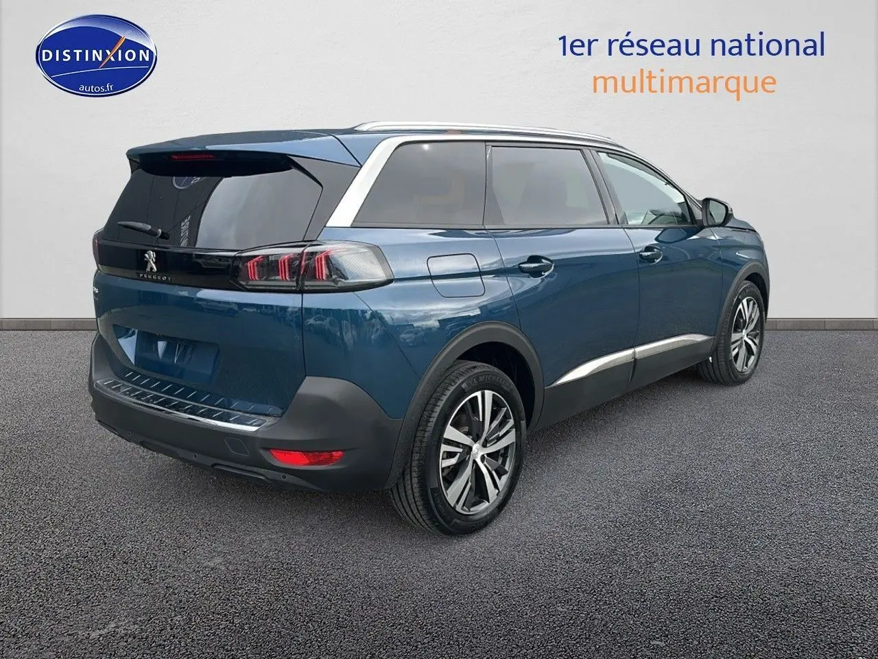 Peugeot 5008 bleu en 3/4 arrière droit, avec vitres teintées et jantes alliage 18 pouces.