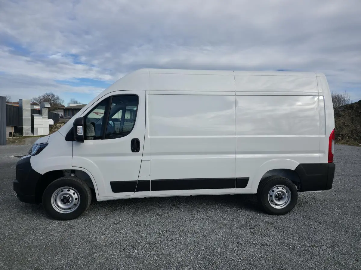Vue de profil côté gauche d'un FIAT Ducato Fourgon blanc 2025 avec porte latérale coulissante et roues acier.