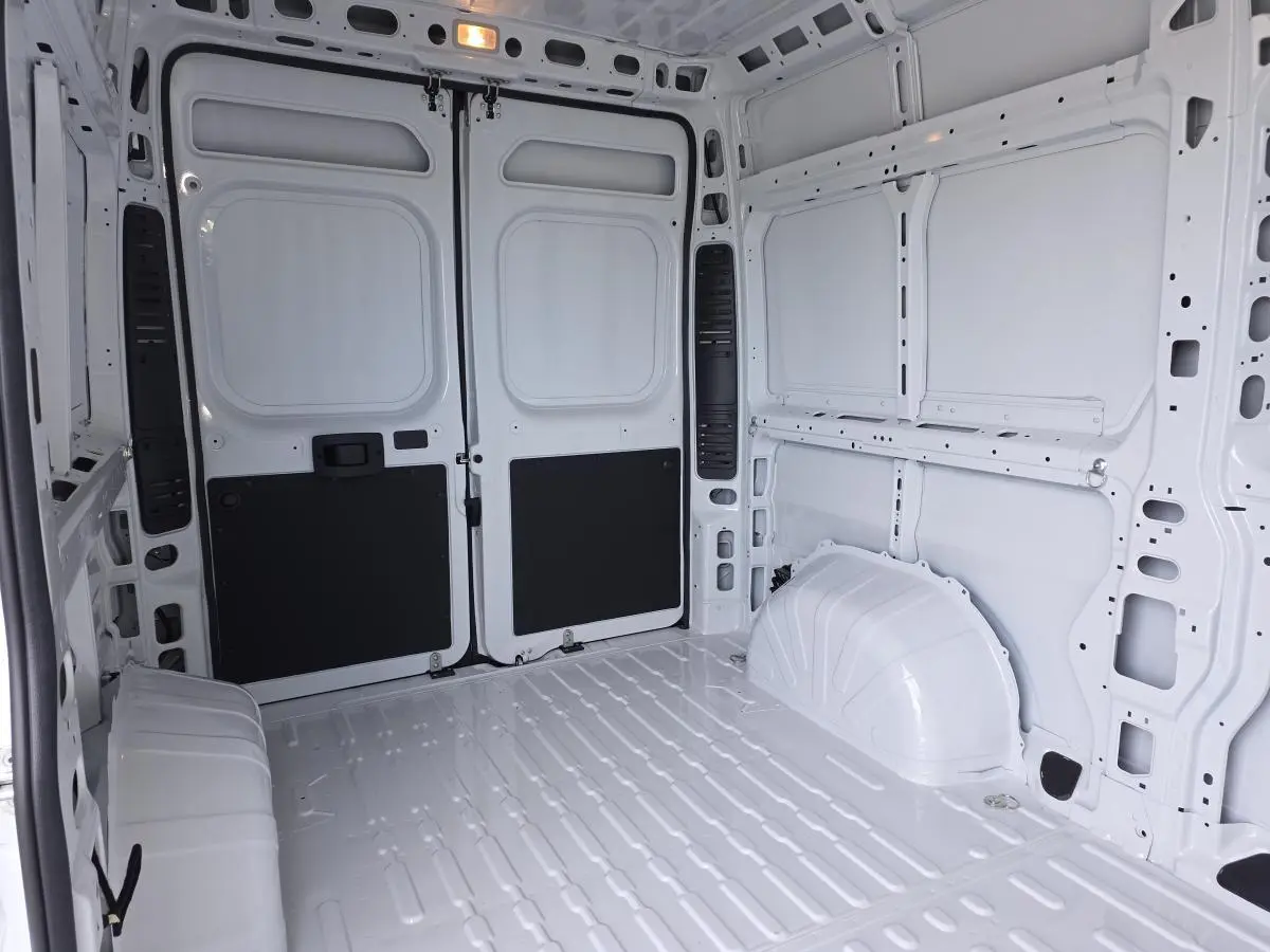 Vue intérieure arrière du fourgon blanc FIAT Ducato Tôlé 3.3 L H2 2.2 avec cloison tôlée et parois métalliques.