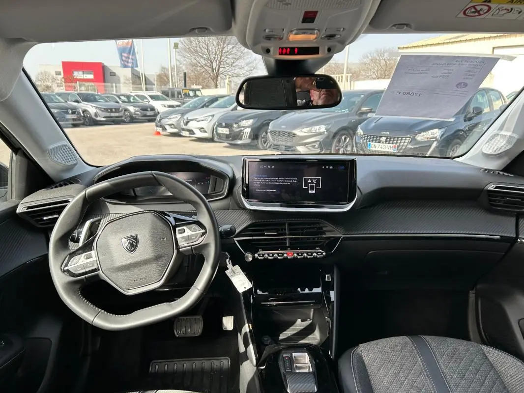 Vue intérieure avant du Peugeot 208 Hybrid 110 e-DCS6 Allure 2024, tableau de bord moderne avec écran tactile central.
