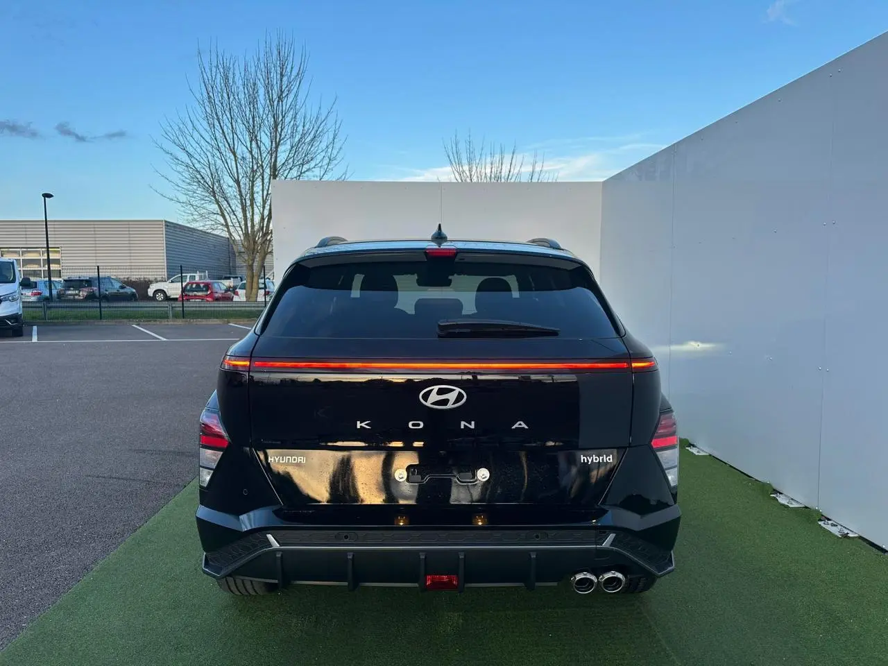Vue arrière d'une Hyundai Kona II 1.6 Hybrid N Line noire Abyss Metal avec feux arrière LED et double sortie d'échappement.