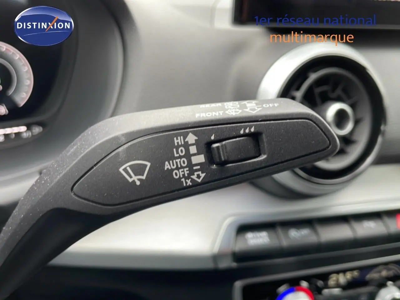 Gros plan sur la commande des essuie-glaces à l'intérieur d'un Audi Q2 noir mito metal, tableau de bord en arrière-plan flou.