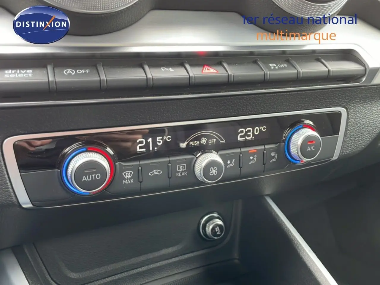 Gros plan sur la console centrale de l'Audi Q2 2025 noire, montrant les commandes de climatisation digitale et boutons de fonction.